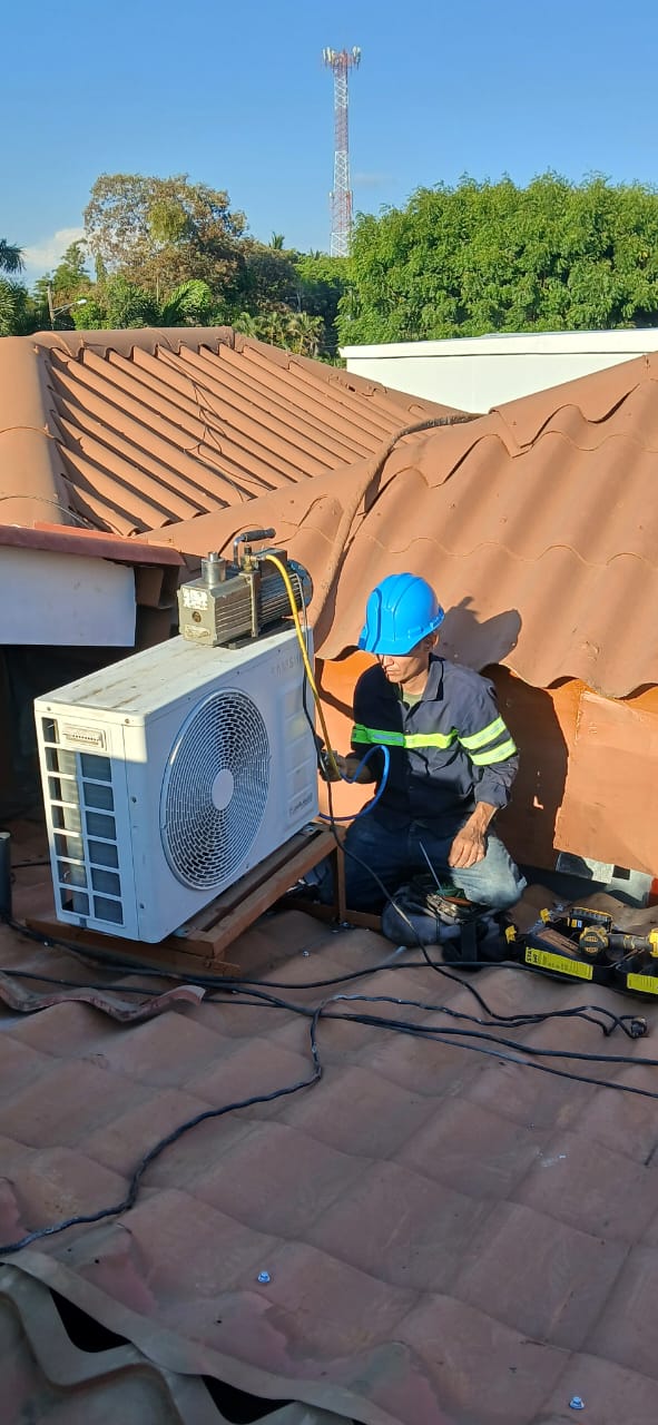 Carga y vacío de unidad condensadora en techo de vivienda